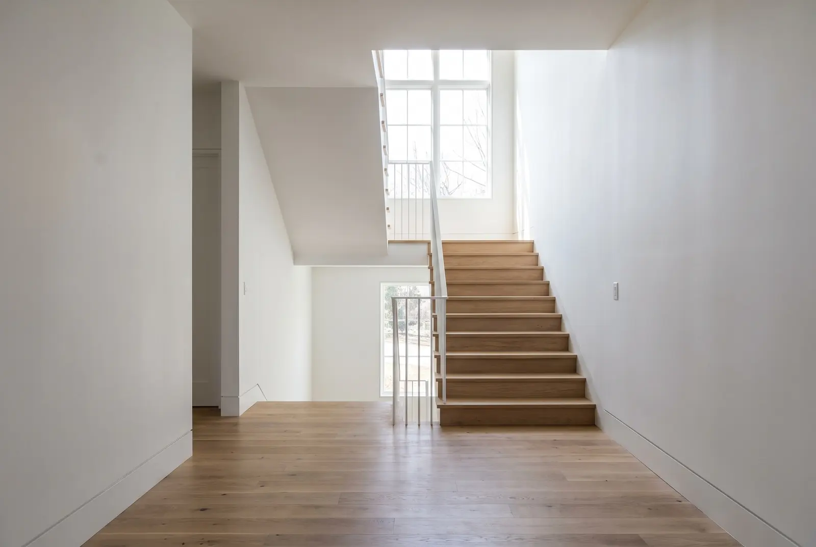 Freshly finished staircase and hallway in a new home, lit by a landing window (illustration) Freshly finished staircase and hallway in a new home, lit by a landing window (illustration)